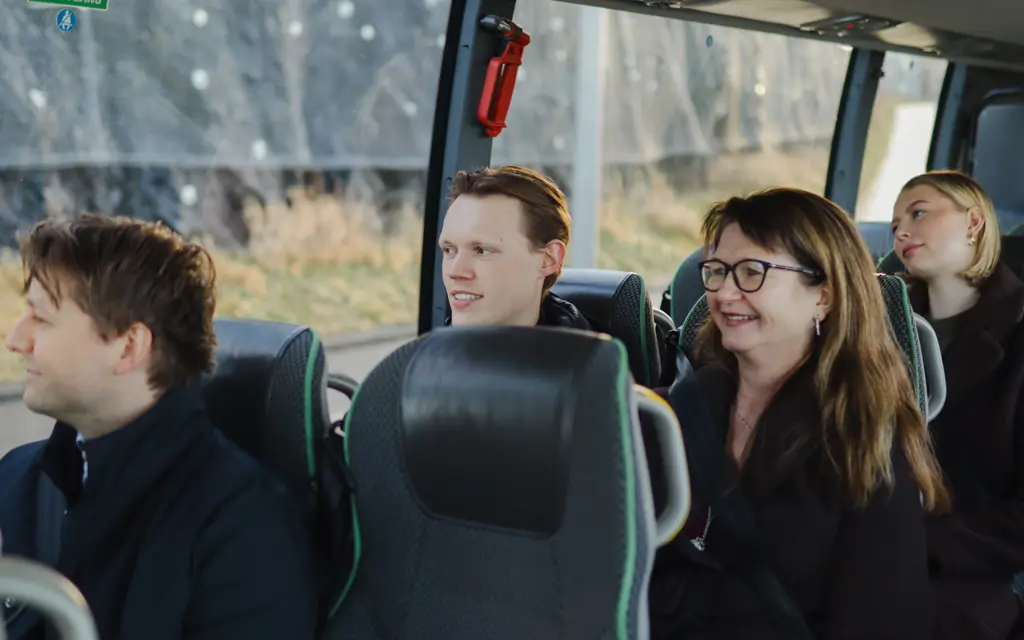 Smilene passasjerer sett inne i en flybuss