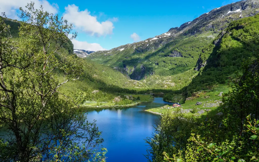 Vakkert landskap med fjellvann og grønne fjellsider