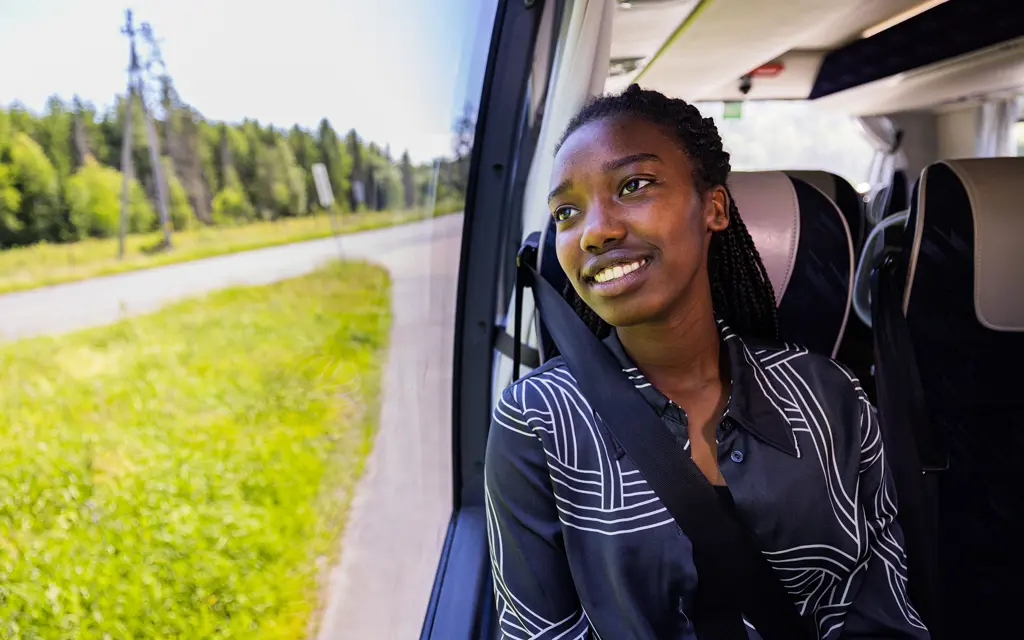 Jente ser ut vinduet på buss